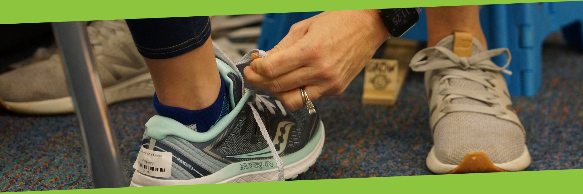 A volunteer tying the laces on a child's running shoes