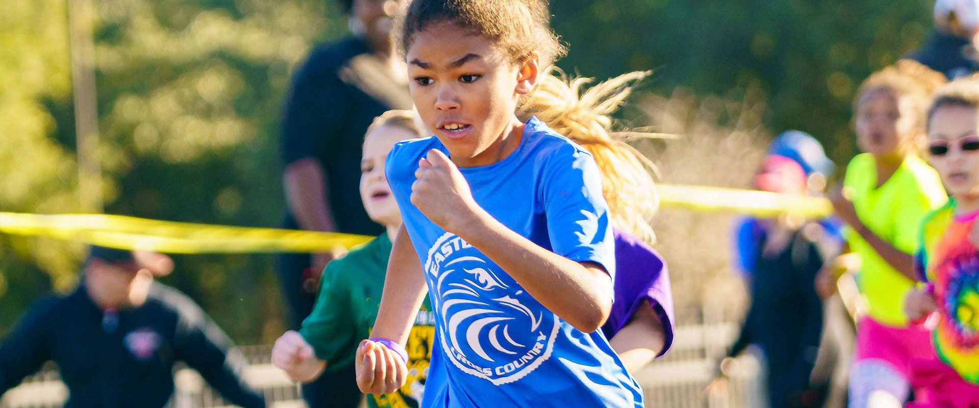 Little girl in a blue shirt running in  a race